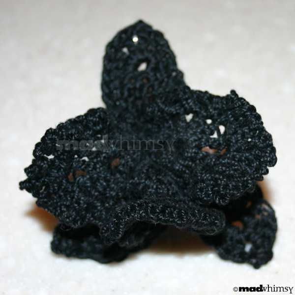 an orchid made of black crochet thread